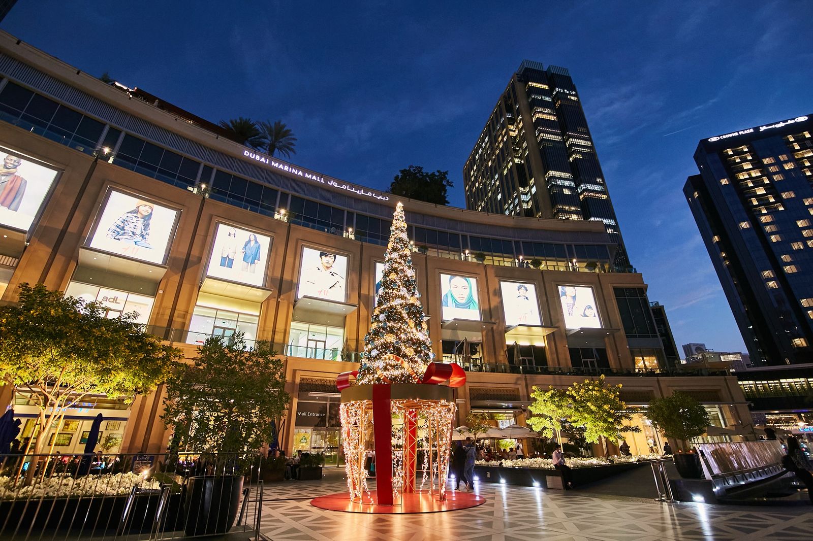 Outdoor Christmas tree installed by Redfox in front of Dubai Marina Mall at dusk